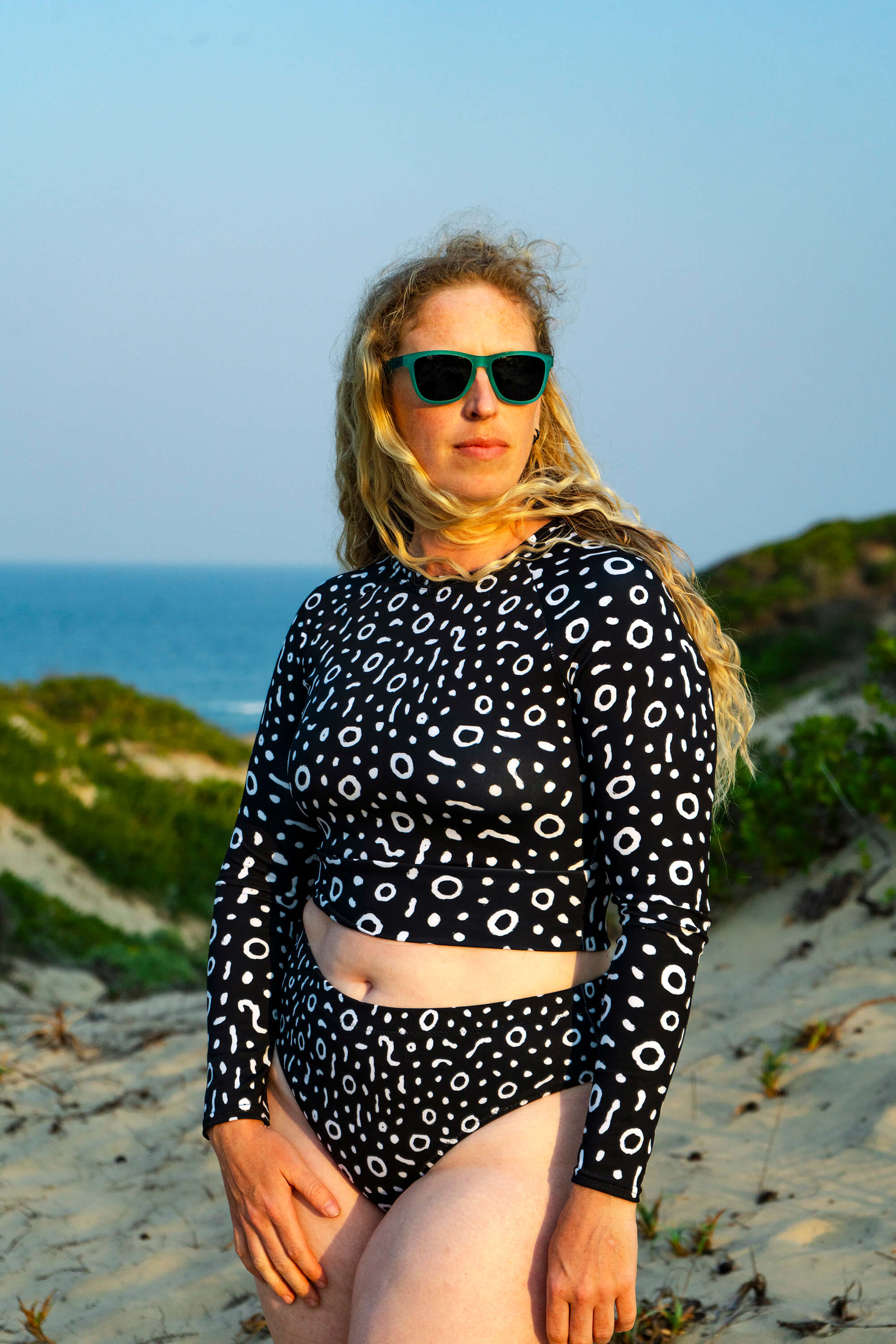 Woman in a black and white patterned swimsuit on a beach